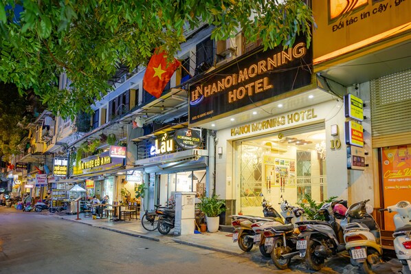 A street view of Hanoi Morning Hotel with multiple motorcycles parked in front. - Hanoi Morning Hotel (Hanoi)