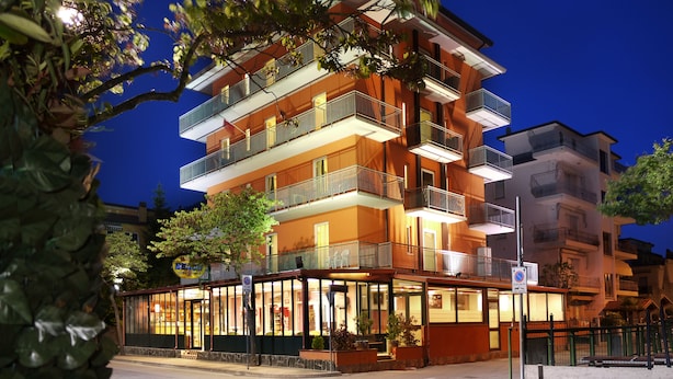 A multi-story hotel with balconies, a ground-level restaurant, and a clear view of the street. - Hotel Beach 2 (Jesolo)