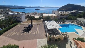 Vista sulla costa con cielo sereno, un'area parcheggio segnalata come 'PARKING ONLY' e una piscina.