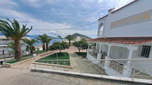 Un hotel costiero con facciata bianca, una terrazza vista mare e un cartello con la scritta "RETOYSA".