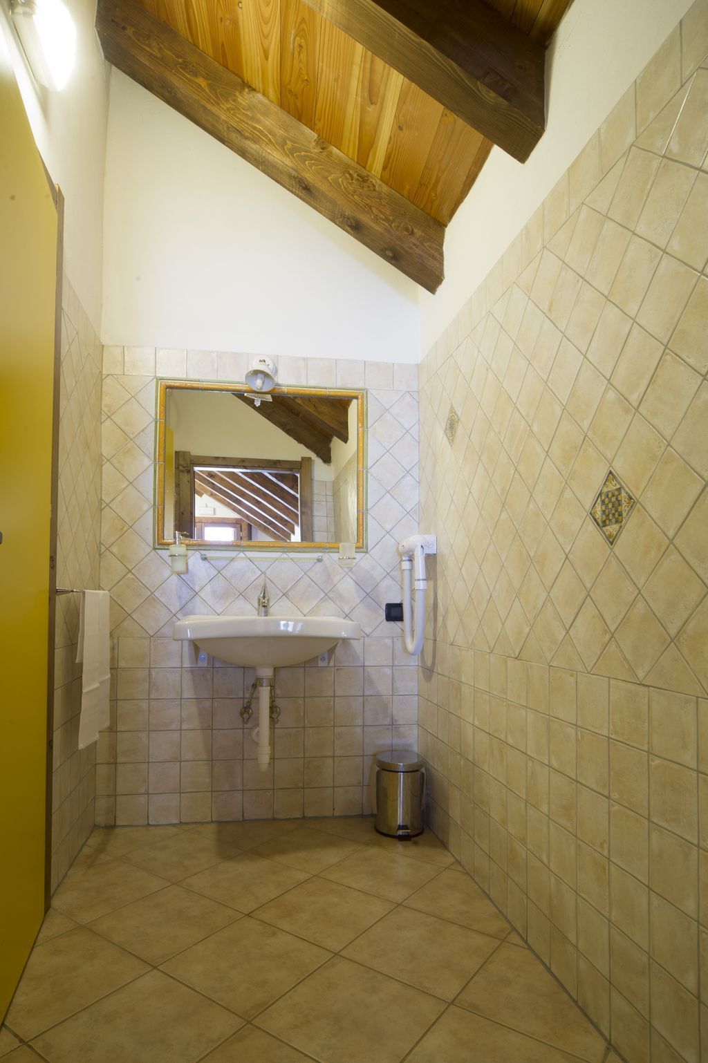 A bathroom with a sink, mirror, and tiled walls.