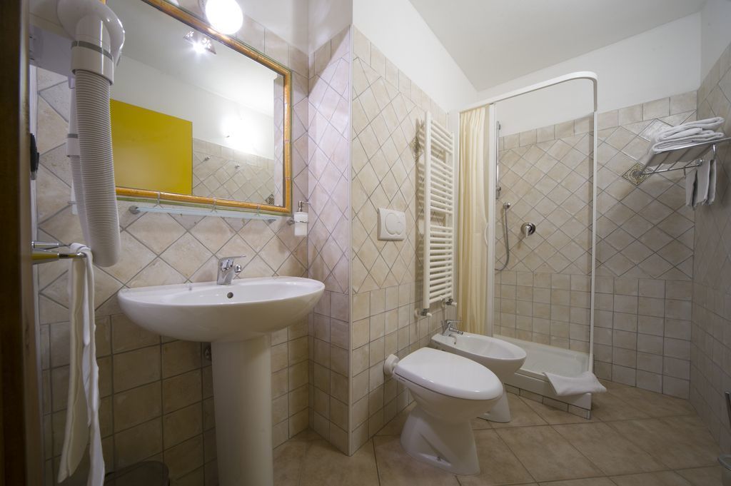 Une salle de bain avec un lavabo, des toilettes et une douche.
