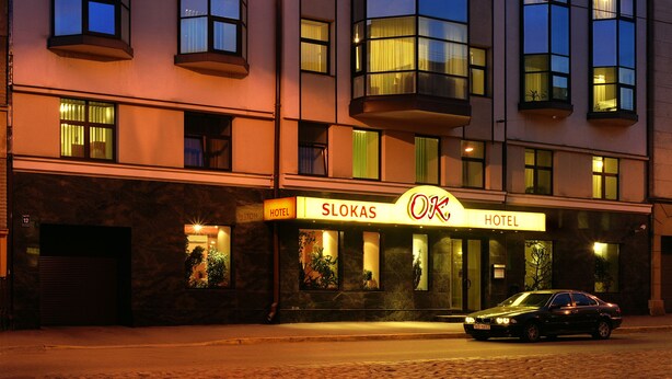 A hotel with a modern facade, large windows, and a prominent sloped roof. - Hotel OK (Riga)