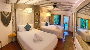 Une chambre d’hôtel avec deux lits, un ventilateur de plafond et un grand miroir.