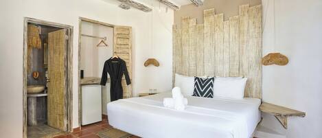 Una habitación de hotel con cama, baño y armario.