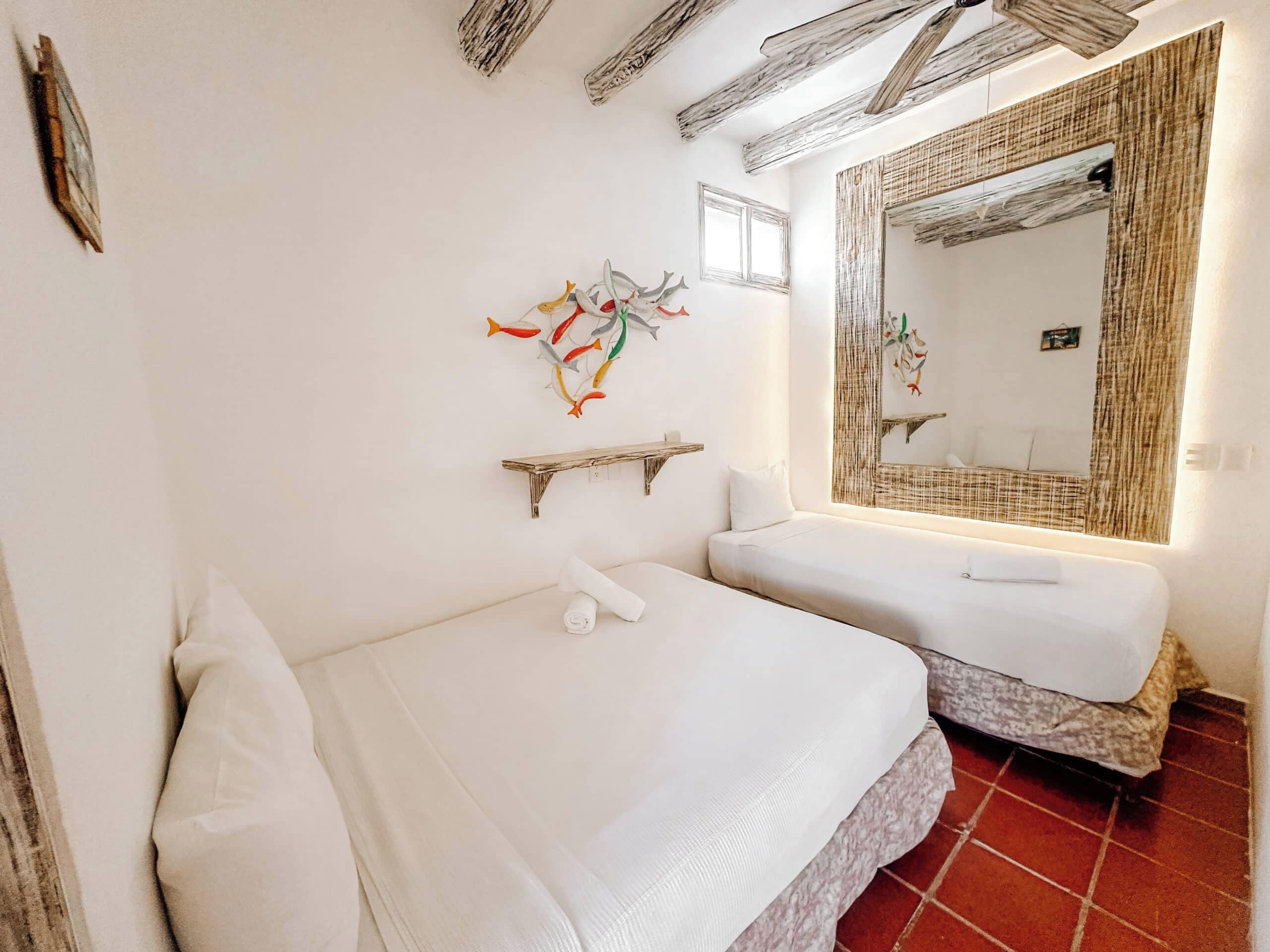 A bedroom with a bed, a bedside table, a mirror, and a wall decoration.