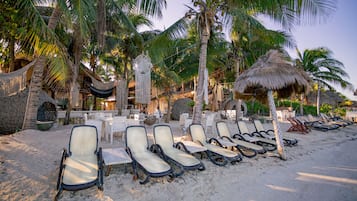On the beach, white sand, sun-loungers, beach towels