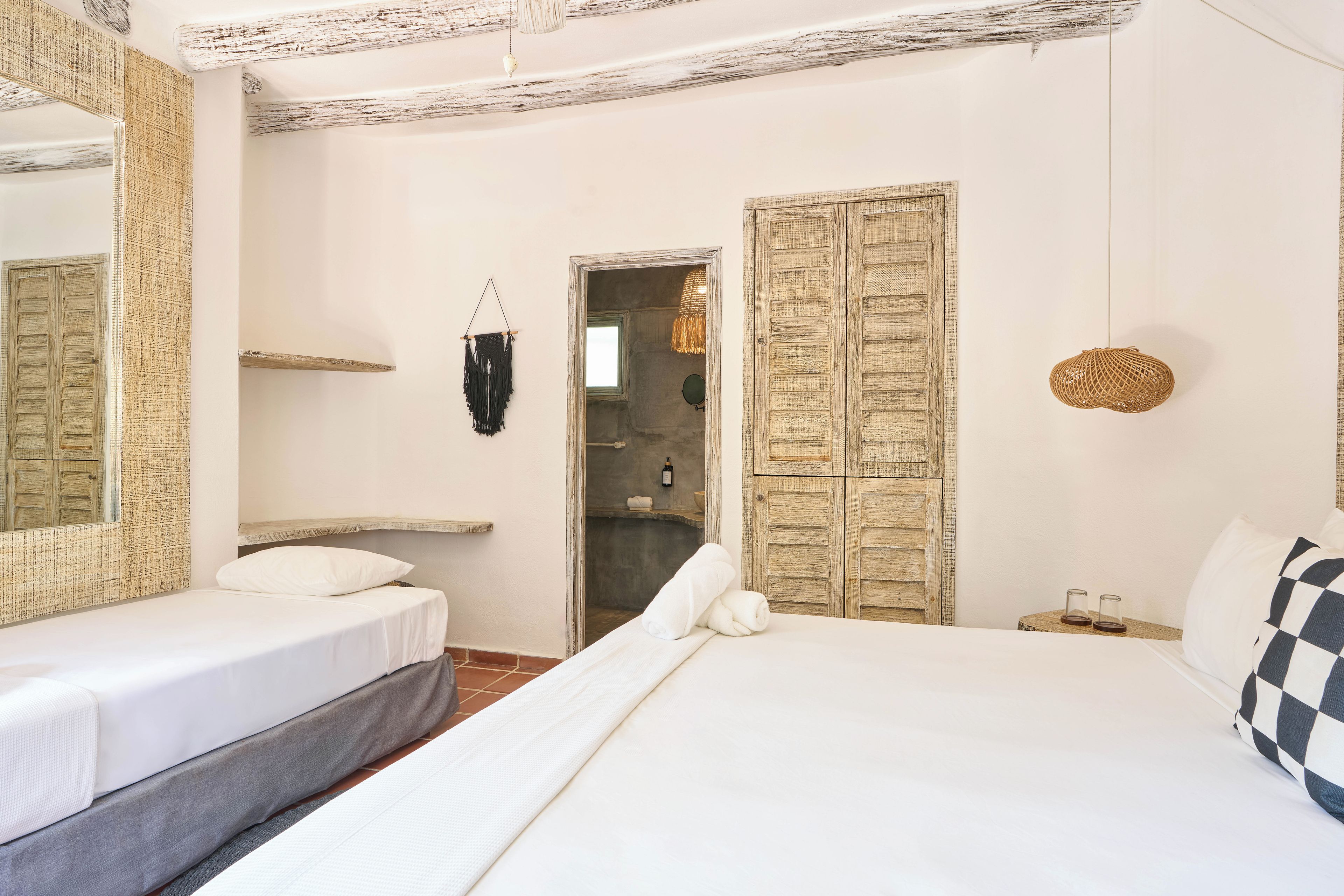 A bedroom with a bed, a bedside table, a hanging light, and a wardrobe.