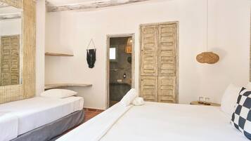 Un dormitorio con cama, mesita de noche, lámpara colgante y armario.
