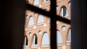 A building facade with multiple arched windows and a central column. - San Francesco Hotel (Loreto)