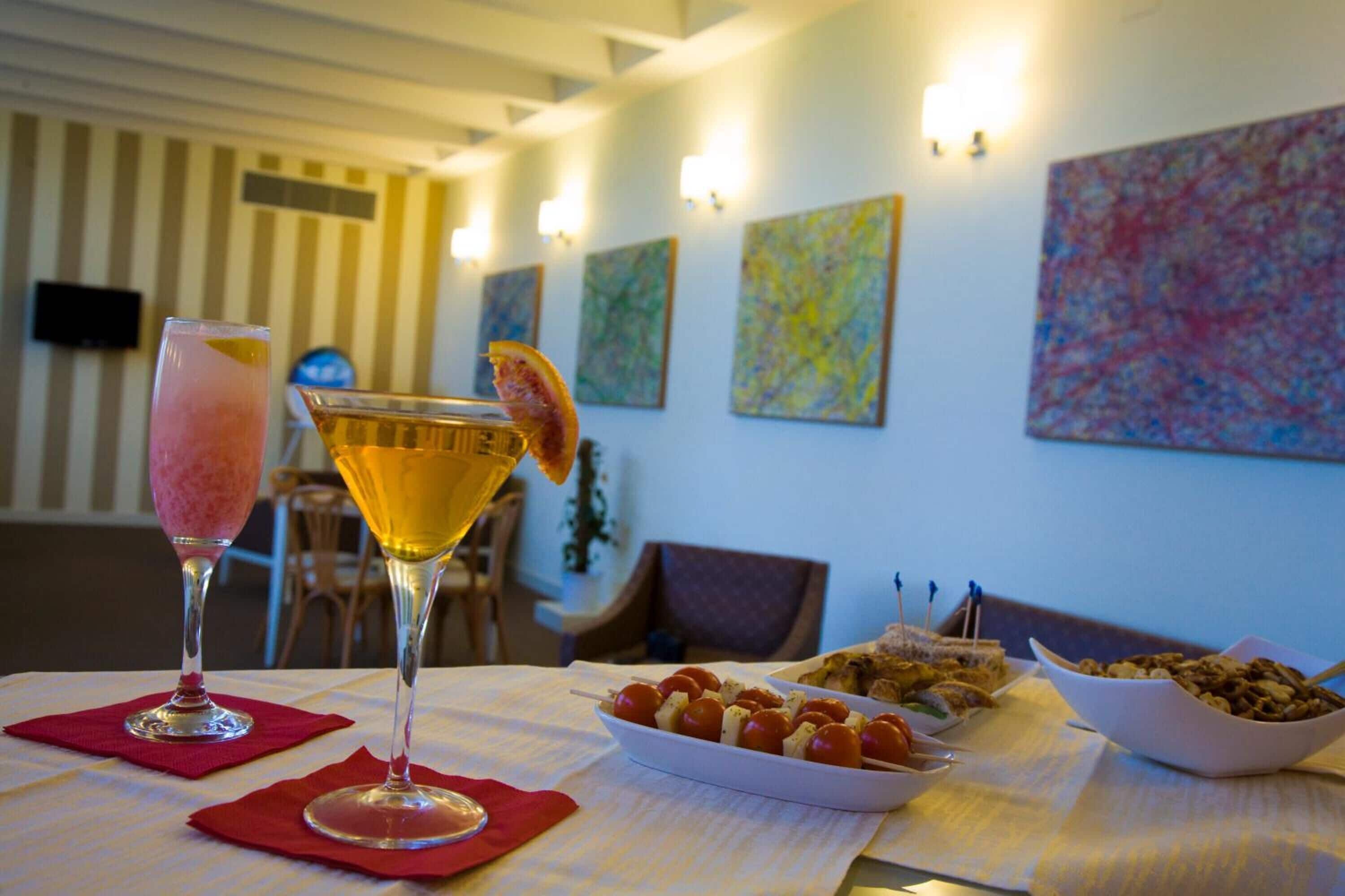Een eettafel met een rijk beleid dessertplateau, een cocktailglas en een martini.