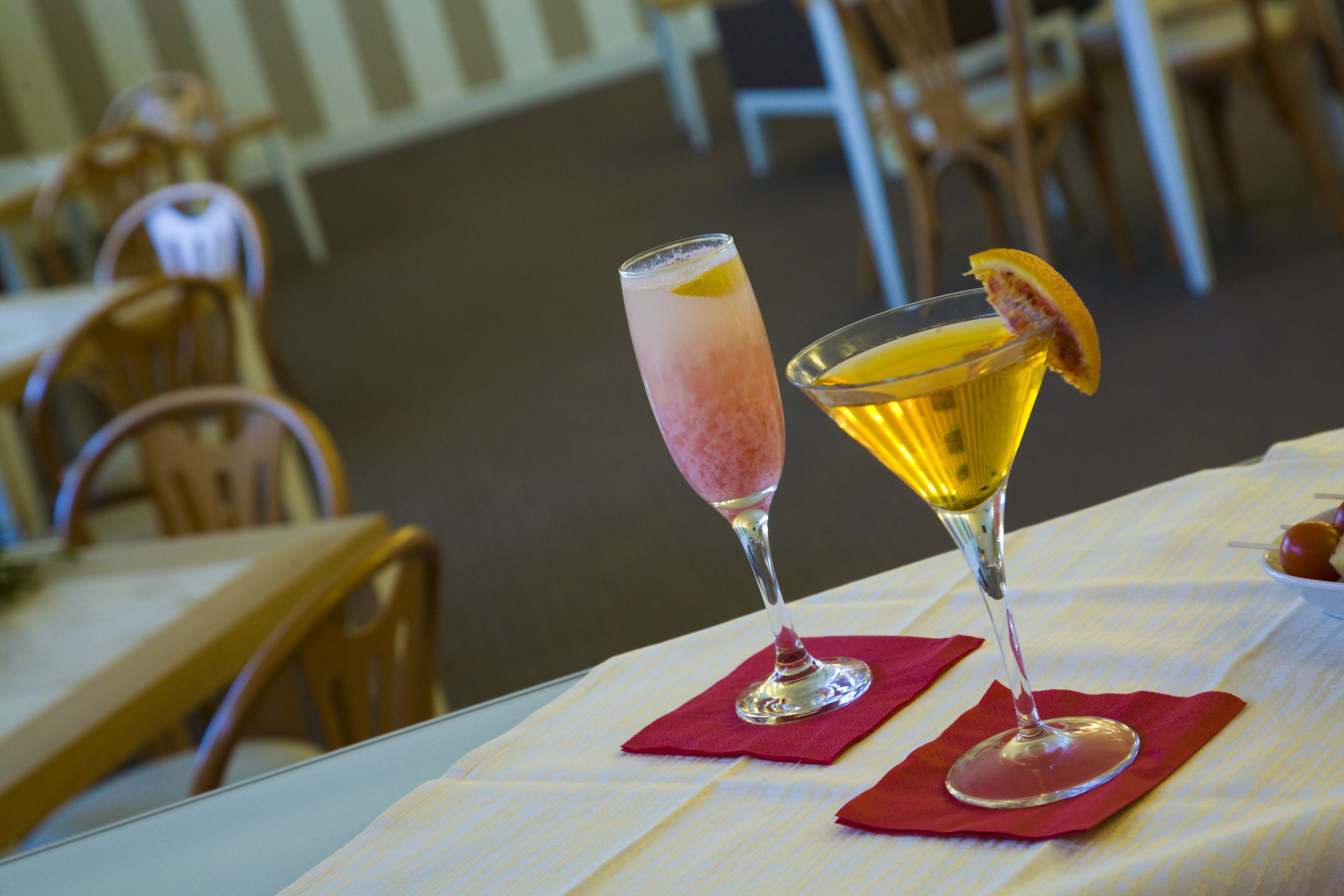 Deux boissons sur une table, avec une serviette rouge, dans un restaurant où les chaises et les tables sont en bois.