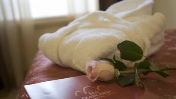 A white bathrobe and a rose on a red hotel brochure.