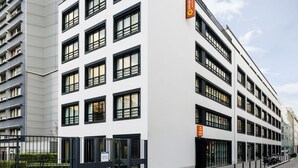 A modern building with multiple floors, large windows, and a sign indicating it is a hotel. - Aparthotel Adagio Access Paris Bastille (Paris)