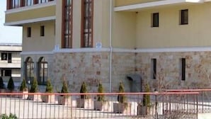 Un hotel de varios pisos con fachada de piedra y techo plano.