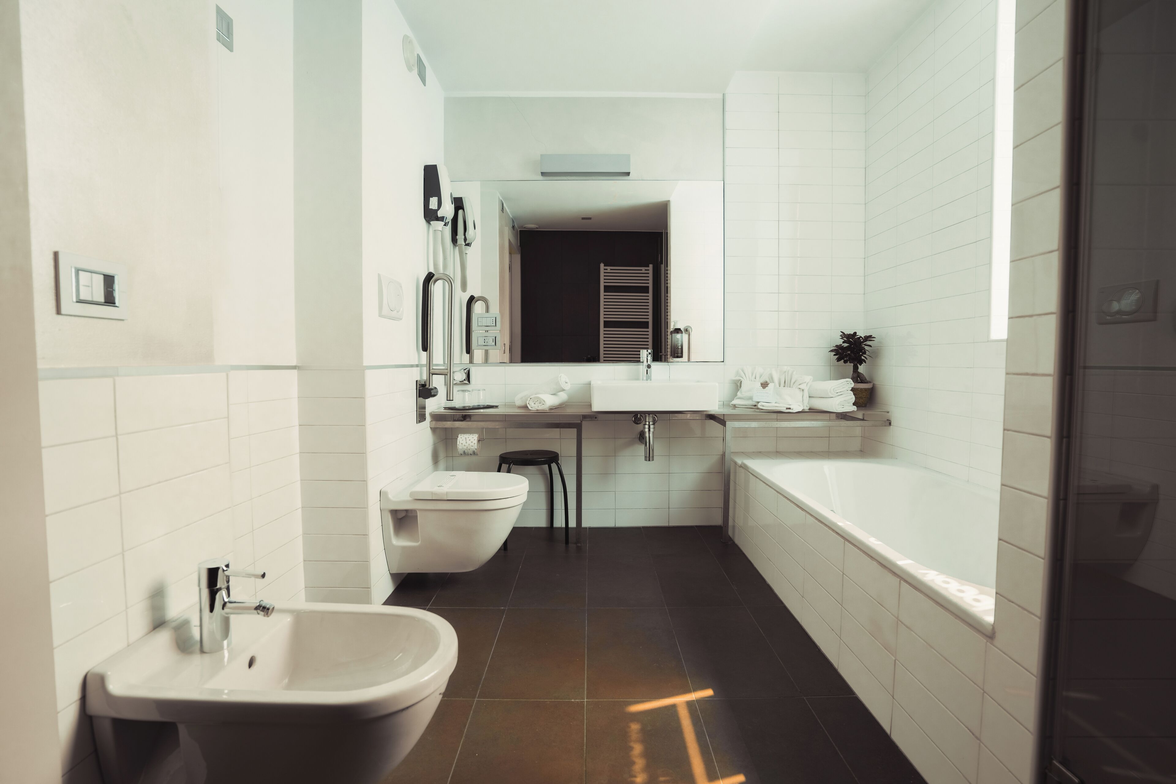 A modern bathroom with a sink, toilet, and bathtub.