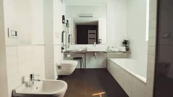 A modern bathroom with a sink, toilet, and bathtub.