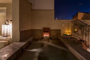 A spa area with a hot tub, a small window, and a staircase.