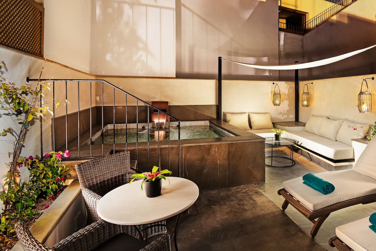 A modern indoor relaxation area with a pool, lounge chairs, and a staircase.