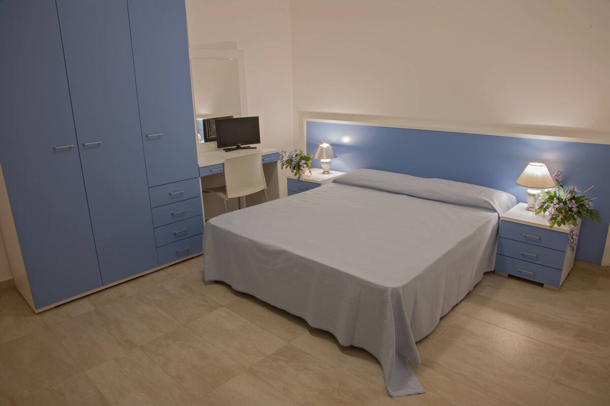 Comfort Quadruple Room | Peralatan tempat tidur premium, meja
