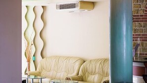 Un intérieur moderne avec un canapé en cuir beige, une table basse en verre et un fauteuil turquoise.
