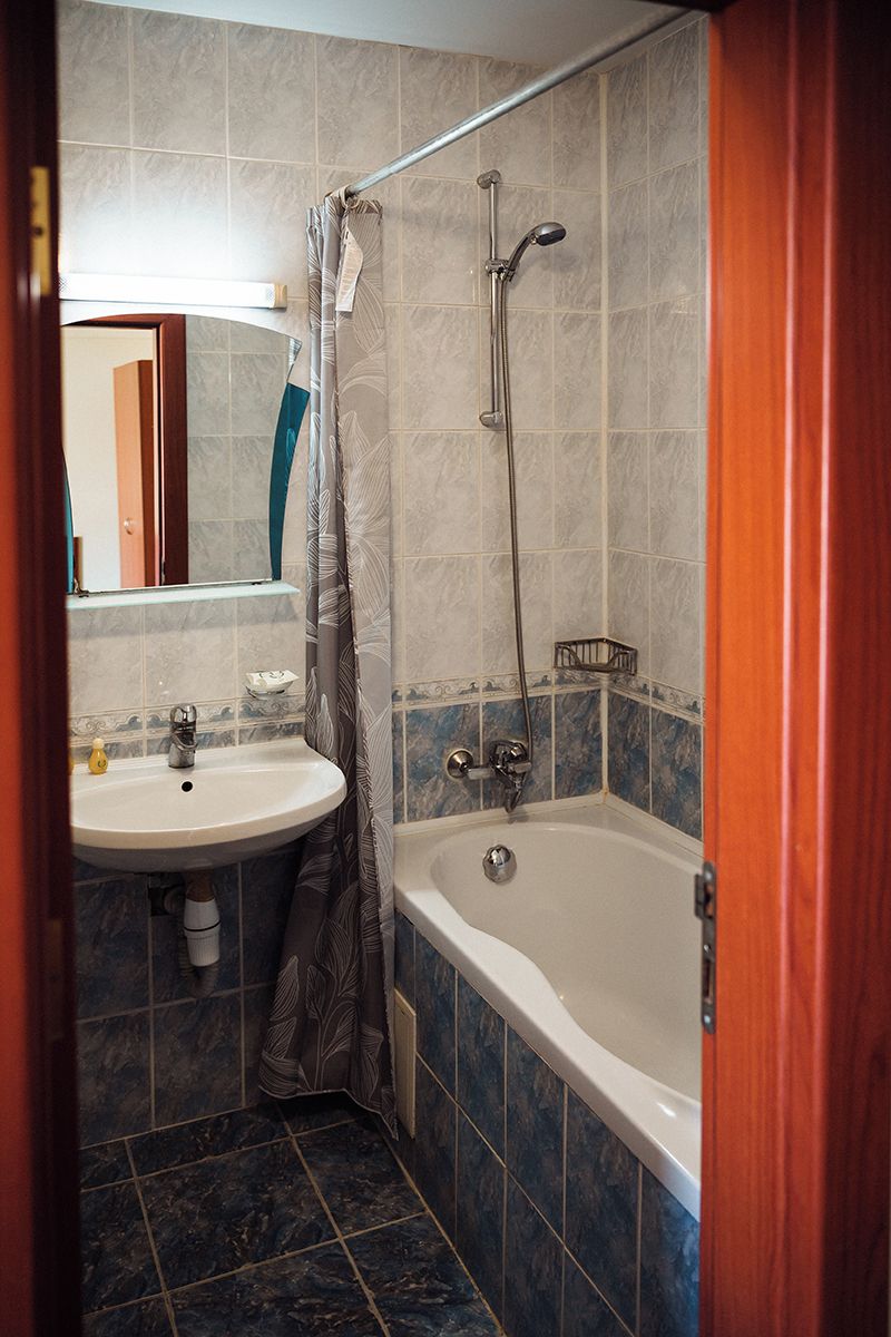 A bathroom with a bathtub, shower, sink, and mirror.