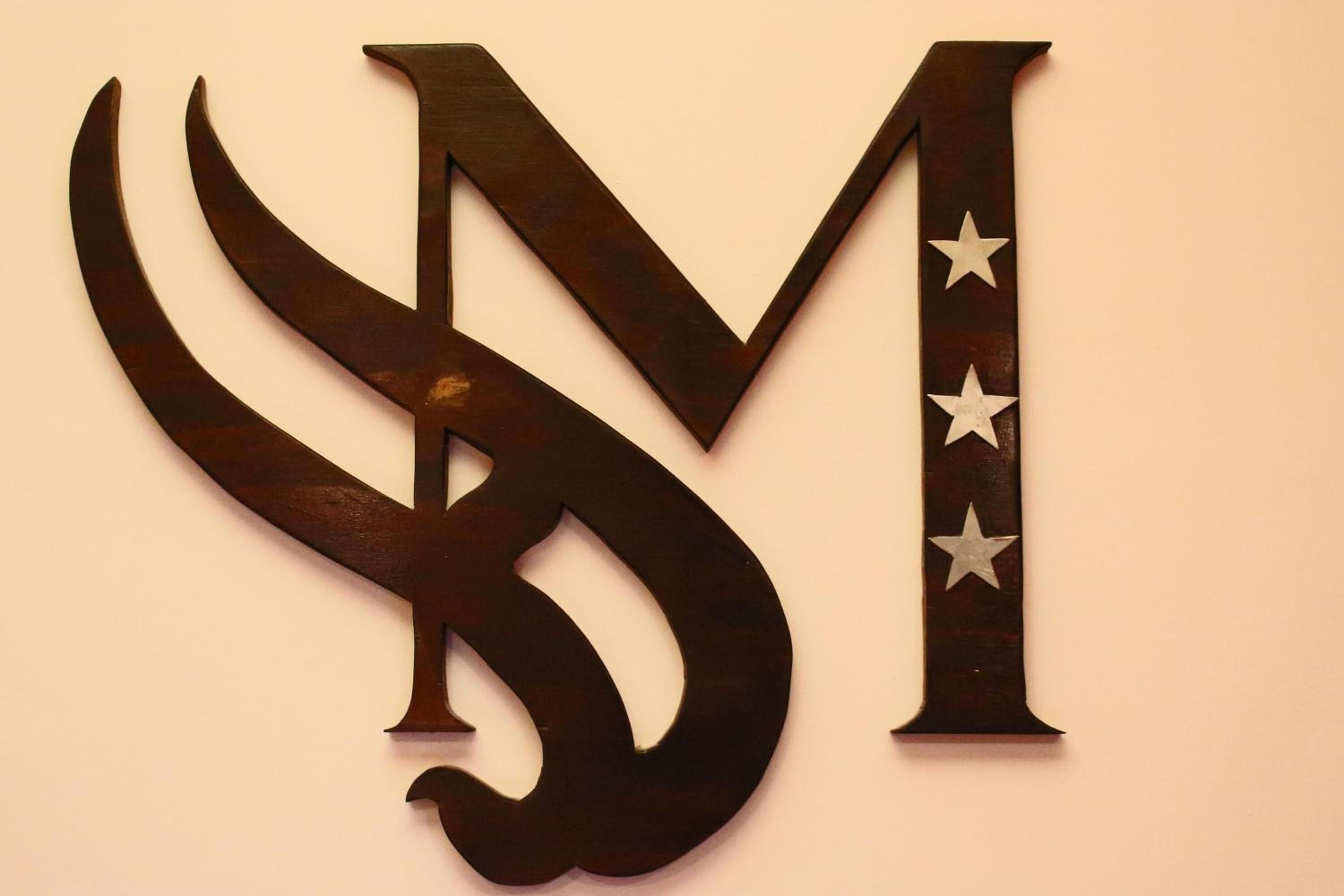 A wall-mounted decorative piece with a stylized letter 'M' and stars.