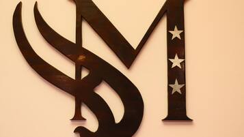 A wall-mounted decorative piece with a stylized letter 'M' and stars.