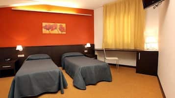 Una habitación de hotel con dos camas, un escritorio, una silla, un televisor y un cuadro en la pared.