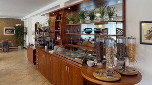 A breakfast bar with a variety of food items and decorative plants. - Casa Chincarini (Malcesine)