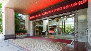 A hotel entrance with a patterned carpet leading to the door, a red carpet outside, and a glass facade. - Lihua Hotel Haikou (Haikou)