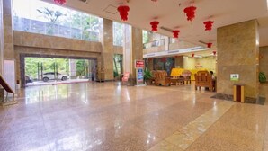 A spacious lobby with a car entrance, a reception desk, and a seating area. - Lihua Hotel Haikou (Haikou)