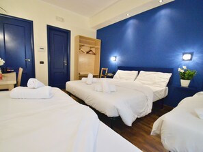 A hotel room with two beds, a wardrobe, and a small table with a plant. - Holiday a San Pietro (Rome)