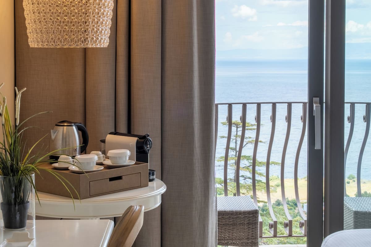 Une chambre d’hôtel avec un balcon, un coin repas et un lit.