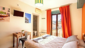 A hotel room with a bed, a desk with a chair, a television, and a window with curtains. - Hotel Merlini (Florence)