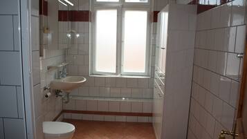 Een badkamer met toilet, wastafel en raam.