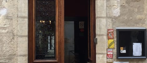 The entrance to a hotel with a sign reading "HOTEL LE SAINT-LUIS HOTEL SALON RESTAURANT".