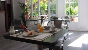 Una mesa de desayuno con tostadas, una taza, un bol y un vaso de jugo de naranja.