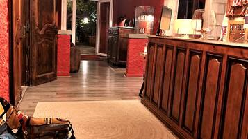 A spacious room with a wooden bar, a large rug, and a view of the outdoors.