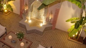 Un amplio vestíbulo de hotel con techo alto, una fuente y varias zonas de estar.