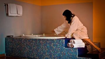 Guests can unwind in a bathtub, surrounded by a neutral-toned space.