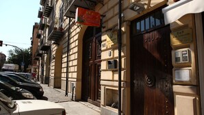 Un edificio con puerta de madera, un cartel que dice B&B Art Lincoln y una calle con coches aparcados.