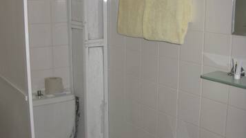 A bathroom with a toilet, sink, and a towel hanging on the wall.