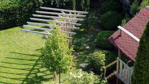 A garden with a wooden pergola structure, surrounded by well-maintained lawns and various shrubs. - Margarita (Varna)