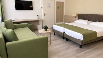 Een hotelkamer met een bed, een bank, een kleine tafel en een televisie.