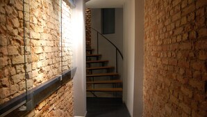 A narrow hallway with brick walls and a wooden staircase. - I'zaz (Istanbul)