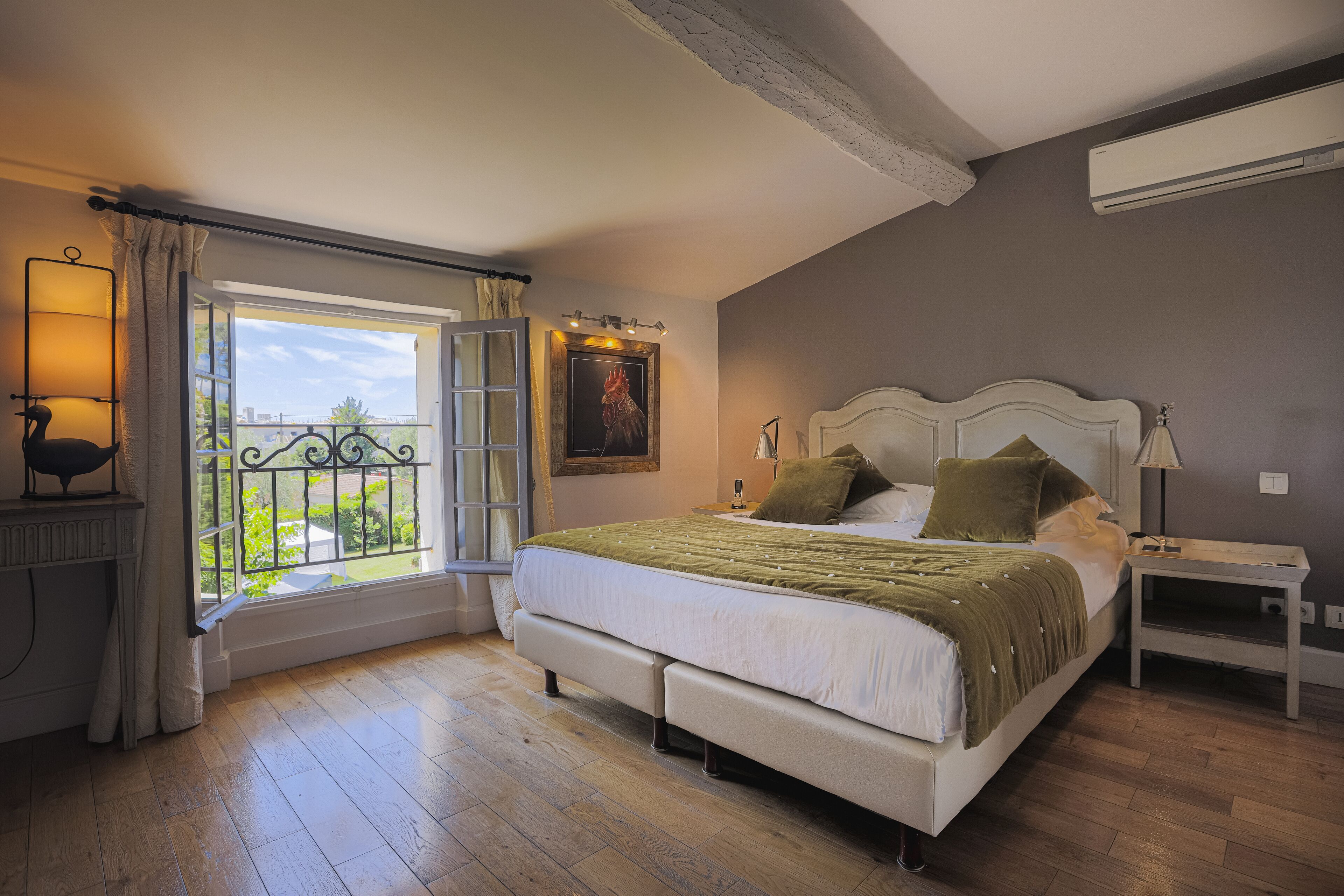 Een slaapkamer met een groot bed, een nachtkastje, een raam met uitzicht en een wandairconditioning.