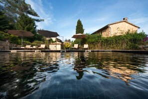 Piscine extérieure en saison, parasols, chaises longues
