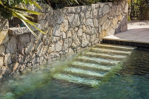 A stone wall with a clear pool. - Hotel du Clos (Le Rouret)