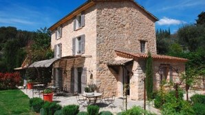 A stone house with a patio, outdoor seating, and a garden. - Hotel du Clos (Le Rouret)
